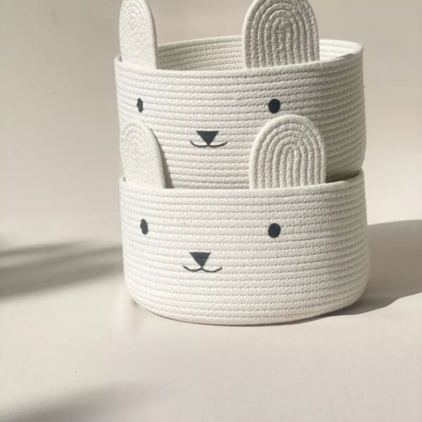 Adorable white cotton rope basket with bunny face and ears, ideal for kids' toy storage and nursery decor.