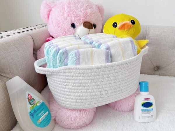 Cotton rope organizer basket filled with kids’ toys and stuffed animals on a sofa