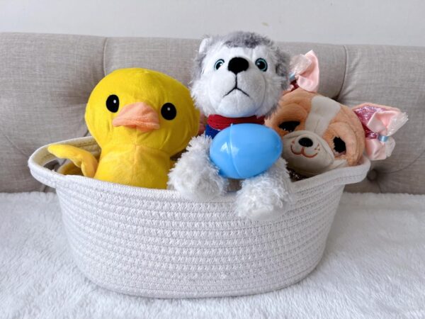 Cotton rope organizer basket filled with kids’ toys and stuffed animals on a sofa