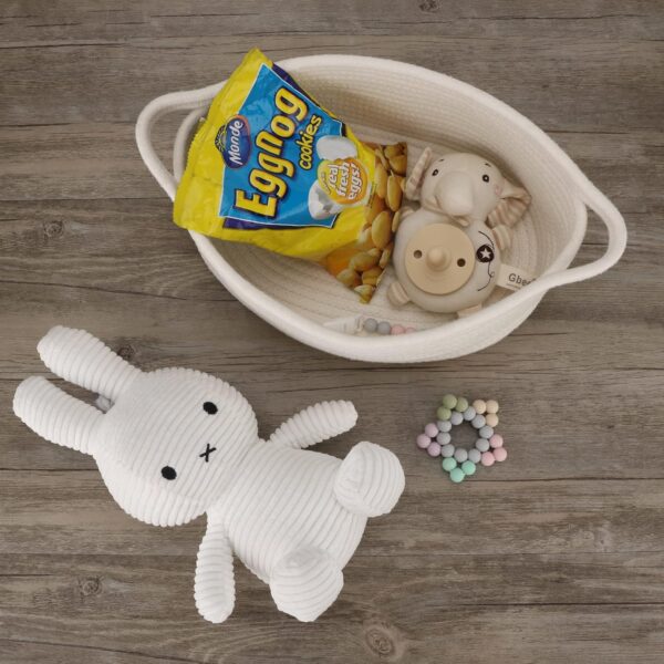 Cotton rope organizer basket filled with kids’ toys and stuffed animals on a sofa