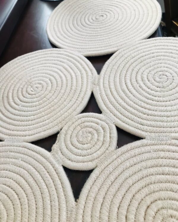 Handcrafted cotton rope table runner with circular patterns, styled on a dining table for rustic decor.