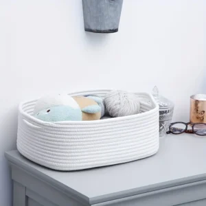 Cotton rope storage basket used for organizing toys and stuffed animals on a table.” “Eco-friendly rope storage basket filled with toiletries on a modern bathroom shelf