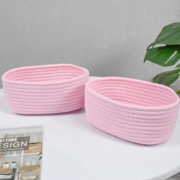 Soft pink cotton rope basket used for toy and book storage in a kids’ room.