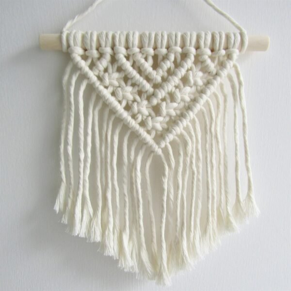 Handmade small macrame wall hanging with V-shaped tassels and wooden rod, perfect for boho home decor.”